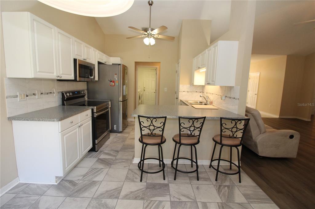 7432 Perennial Road North Port, FL 34291 - Photo 22 of 61 a kitchen with granite countertop a sink cabinets and stainless steel appliances