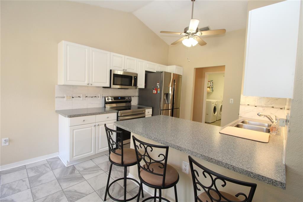 7432 Perennial Road North Port, FL 34291 - Photo 24 of 61 a kitchen with stainless steel appliances a table and chairs in it