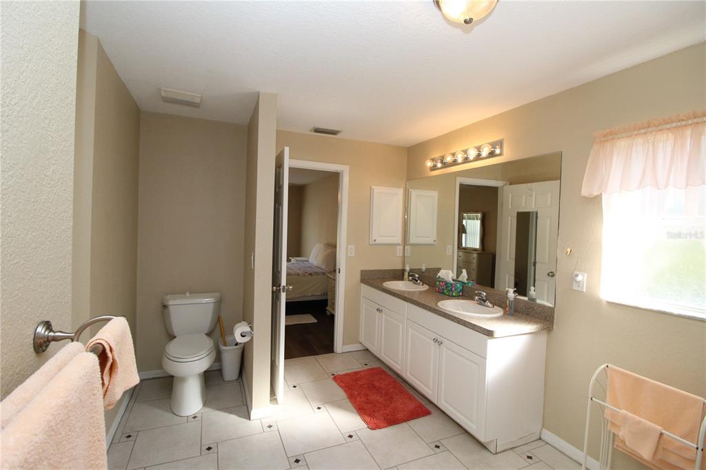 7432 Perennial Road North Port, FL 34291 - Photo 36 of 61 a bathroom with a granite countertop sink mirror vanity and toilet