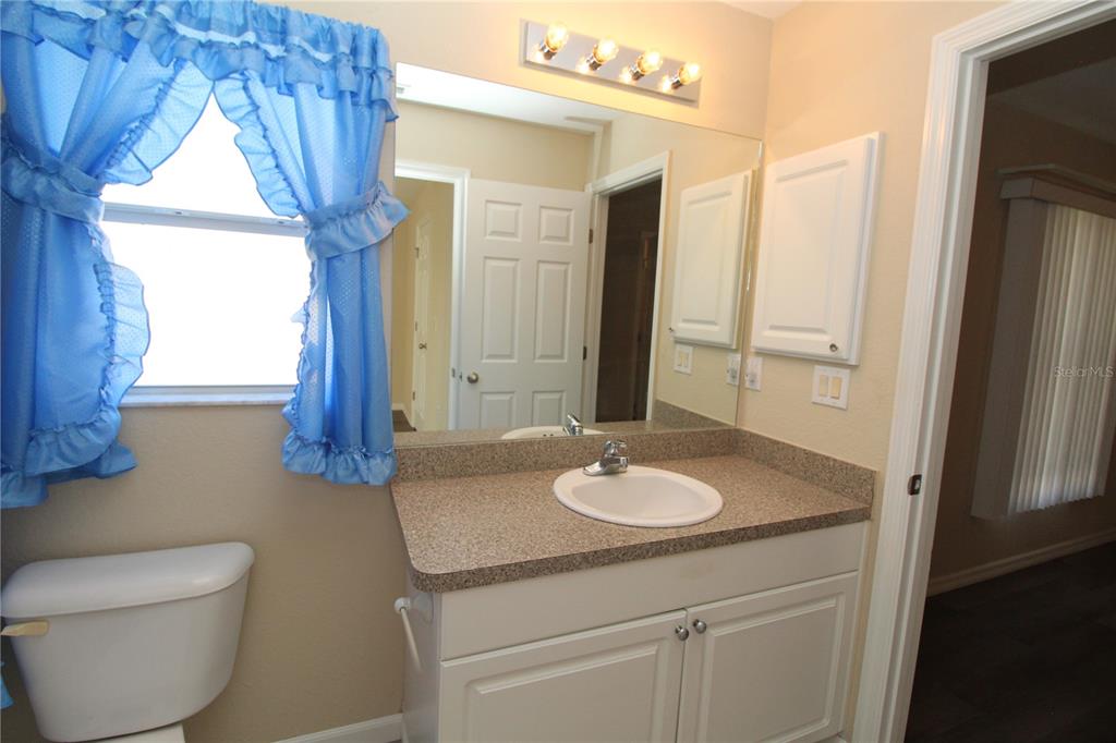 7432 Perennial Road North Port, FL 34291 - Photo 44 of 61 a bathroom with a granite countertop sink toilet and mirror