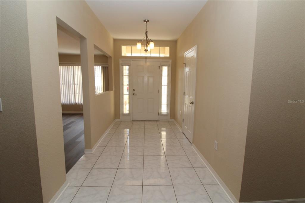 7432 Perennial Road North Port, FL 34291 - Photo 8 of 61 a view of a hallway with chandelier and glass door