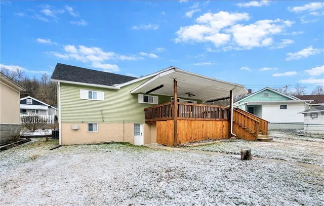 a view of a house with backyard and wooden fence