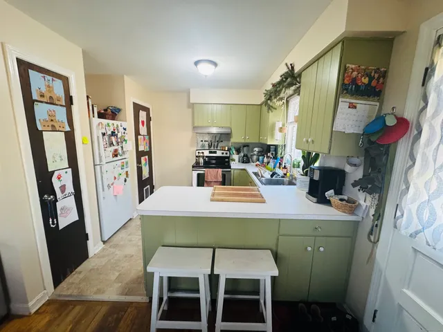 a dining room with wooden floor and large windows