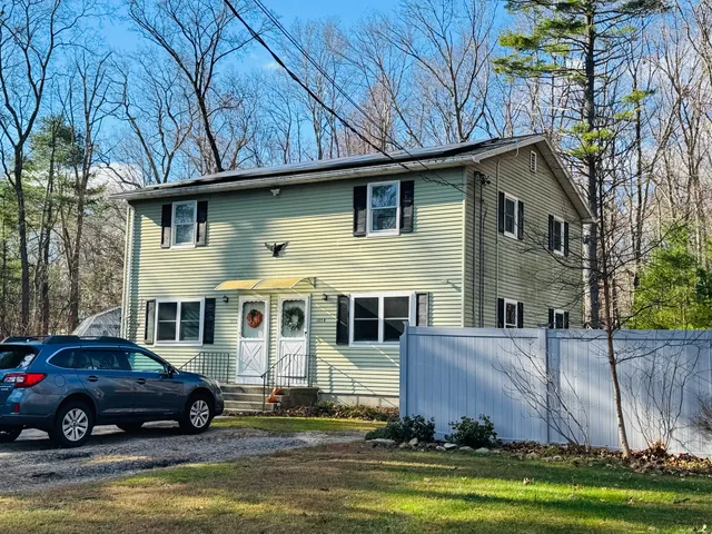 a front view of a house with a garden and yard