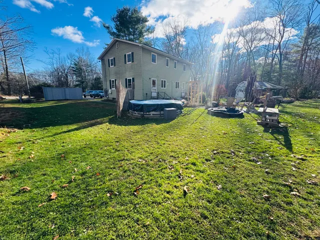 a view of backyard with swimming pool and green space