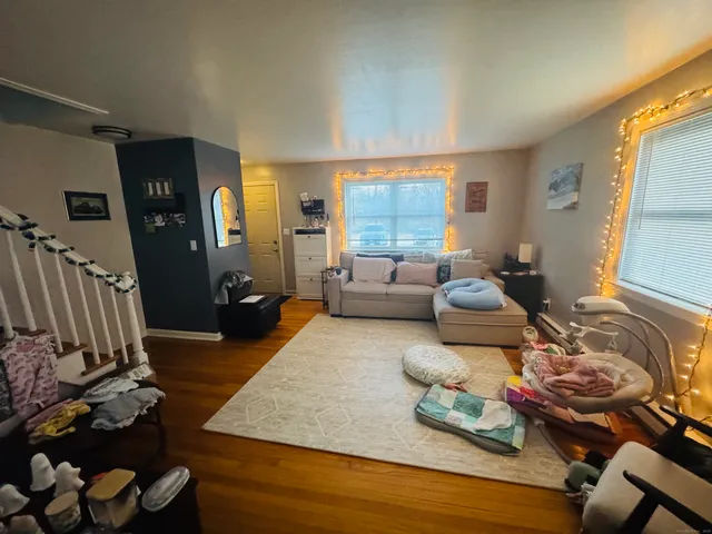 a living room with furniture and a wooden floor