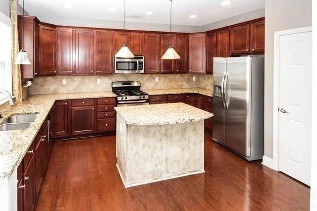 a kitchen with a refrigerator sink and wooden cabinets