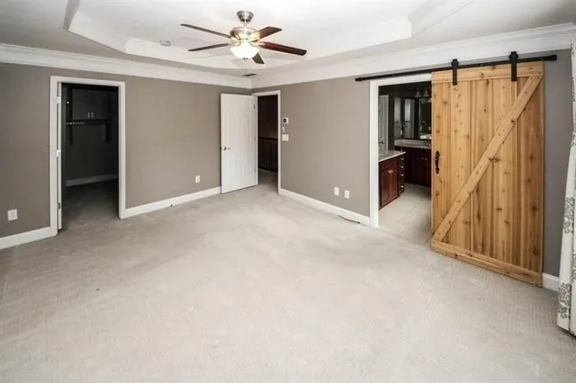 an empty room with closet and a ceiling fan