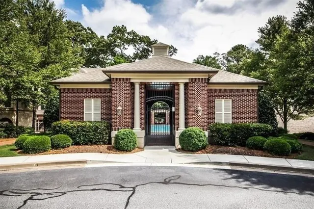 a front view of a house with yard and tress