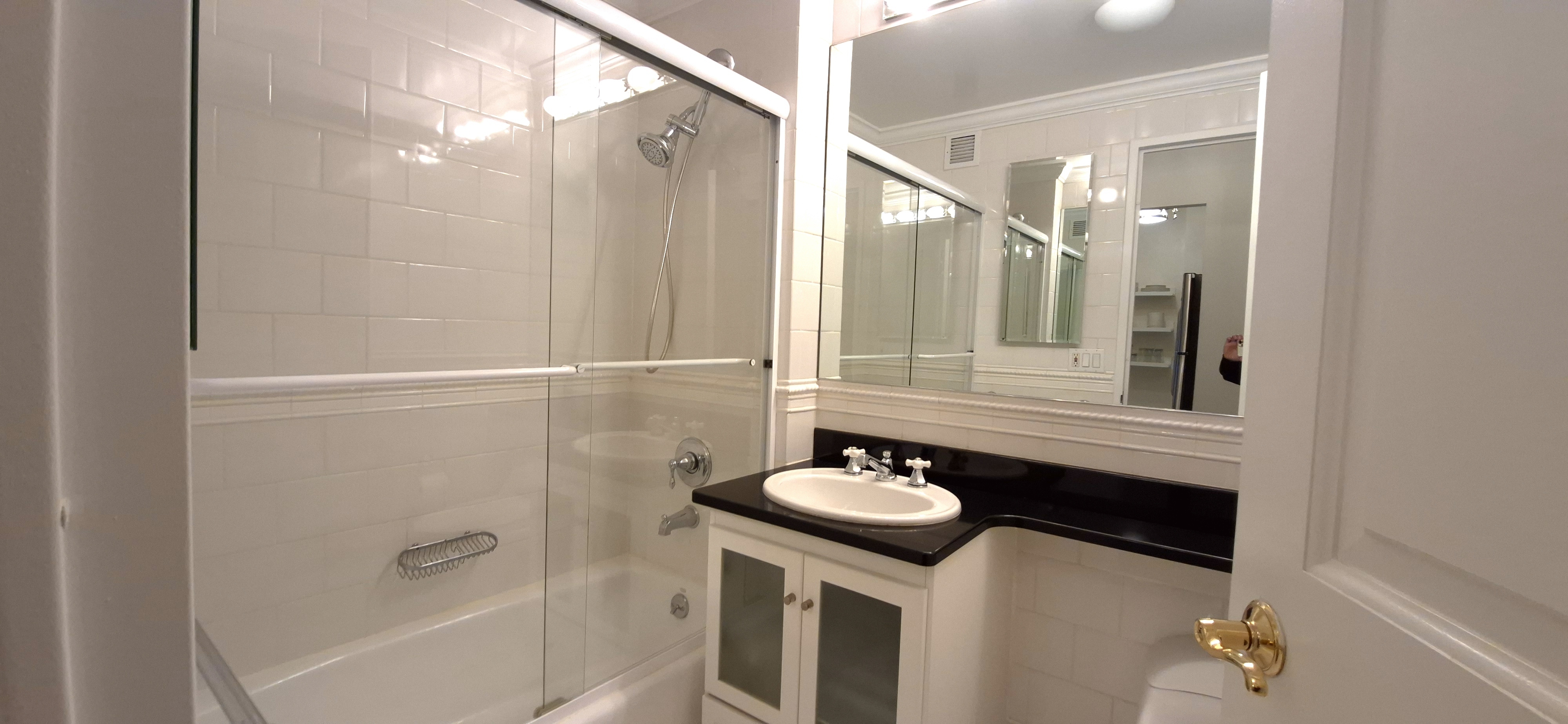 400 East 90th Street, Unit 4D Manhattan, NY 10128 - Photo 7 of 12 a bathroom with a sink a mirror and a shower
