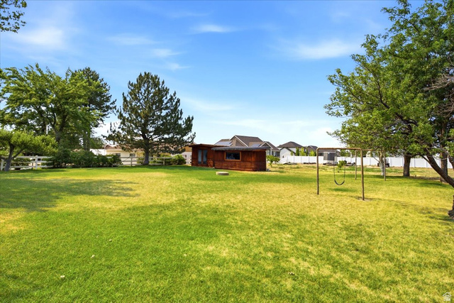 2252 West 800 North Clinton, UT 84015 - Photo 31 of 38 Expansive grassy yard featuring mature trees and a swing set