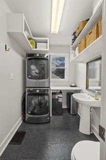 a living room with stainless steel appliances furniture a rug and a fireplace