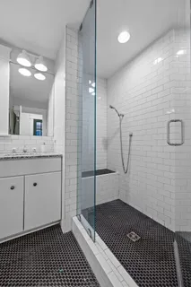a bathroom with a granite countertop sink a toilet and shower