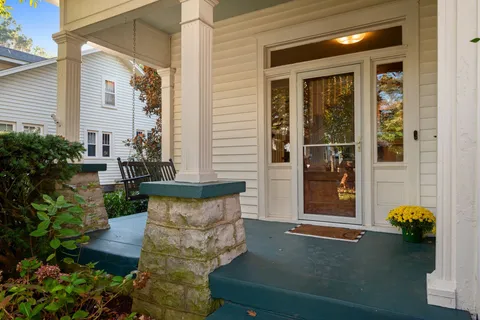 a view of a door of the house with potted plants