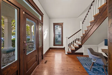 a view of entryway and hall with wooden floor