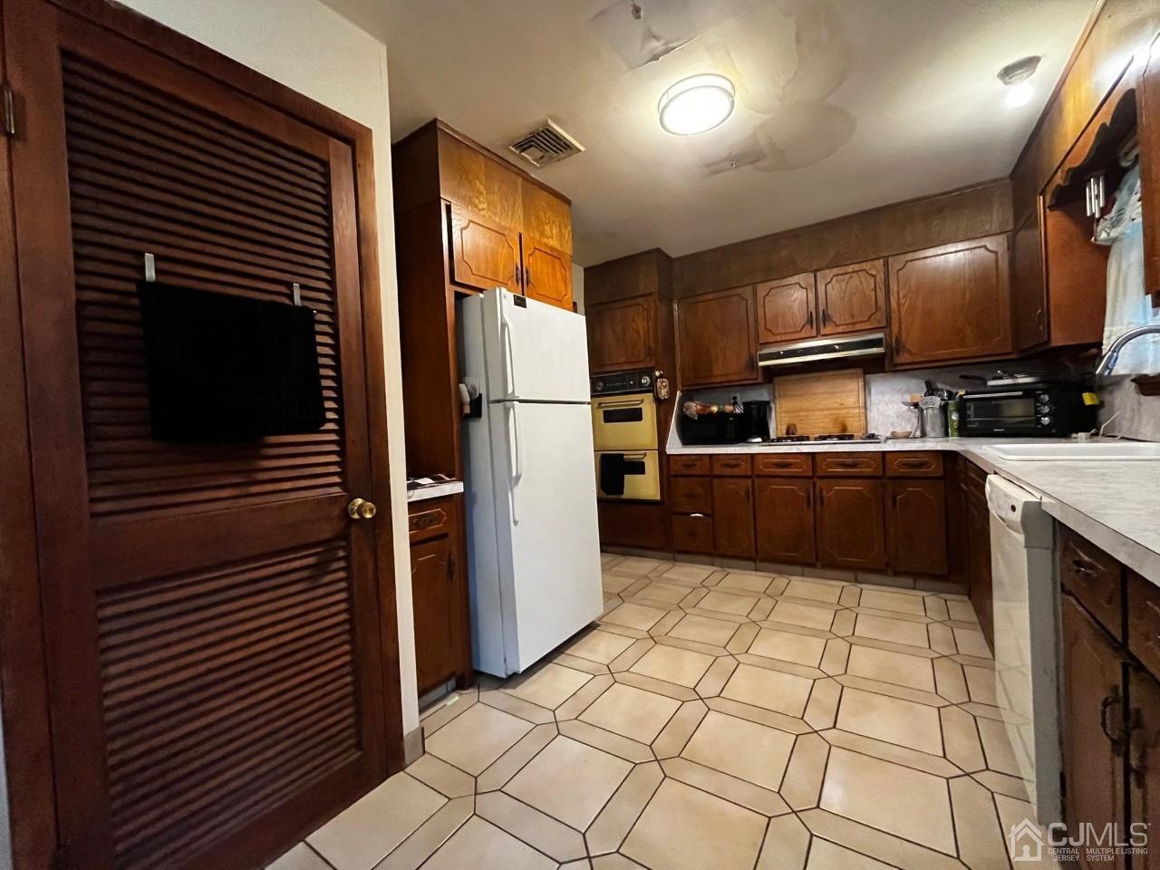 180 Amboy Road Old Bridge, NJ 07747 - Photo 7 of 29 a kitchen with granite countertop a refrigerator and a sink