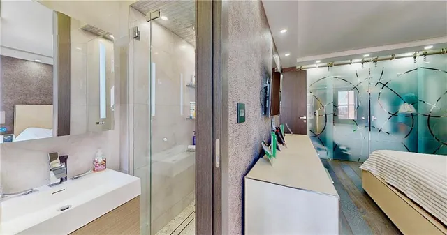 a en suite bathroom with a double vanity sink a mirror and shower