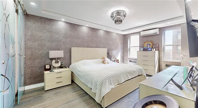 a bedroom with a bed and a chandelier