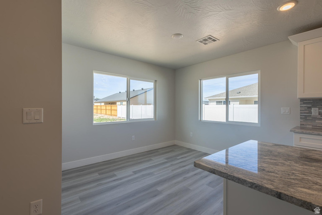 910 East Remington Road Cedar City, UT 84721 - Photo 7 of 29 Kitchen area featuring a stone countertop peninsula, white shaker cabinetry, and a mosaic tile backsplash