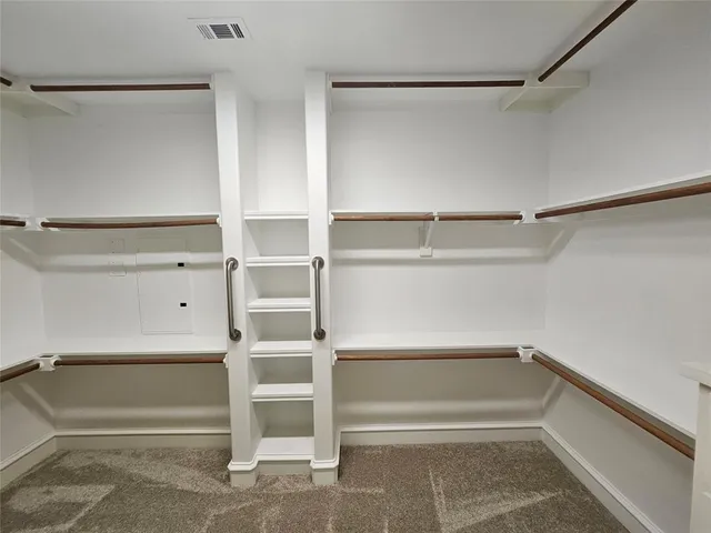 a view of walk in closet with empty racks