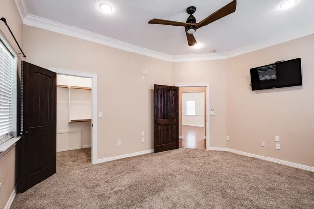 an empty room with a window and a ceiling fan