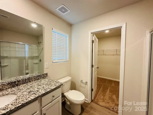 a bathroom with a granite countertop sink toilet and shower