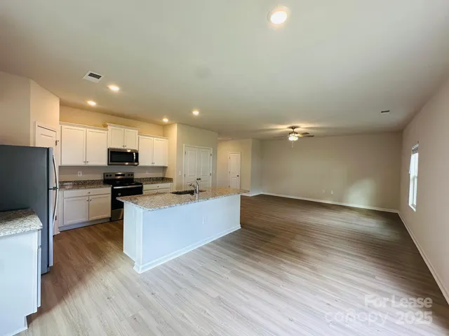 a view of kitchen with wooden floor and electronic appliances