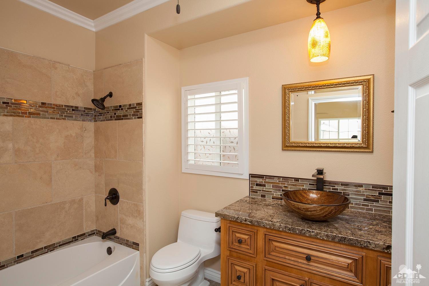 79338 Cool Reflection La Quinta, CA 92253 - Photo 11 of 16 a bathroom with a granite countertop sink a toilet and shower