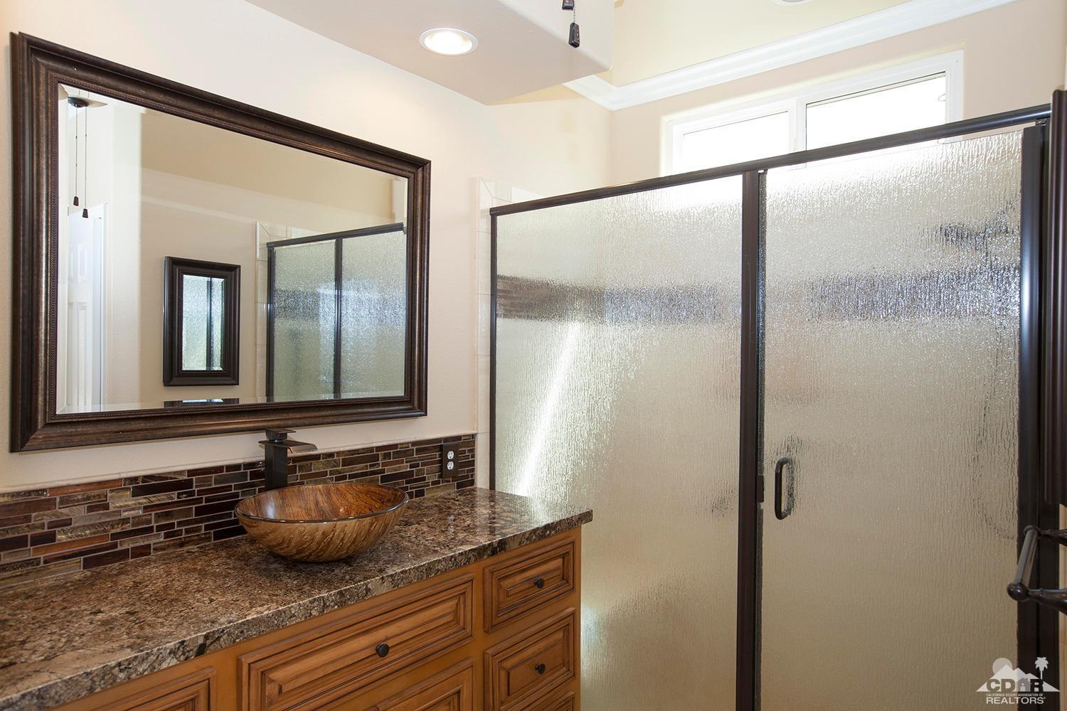 79338 Cool Reflection La Quinta, CA 92253 - Photo 14 of 16 a bathroom with a granite countertop sink and a mirror