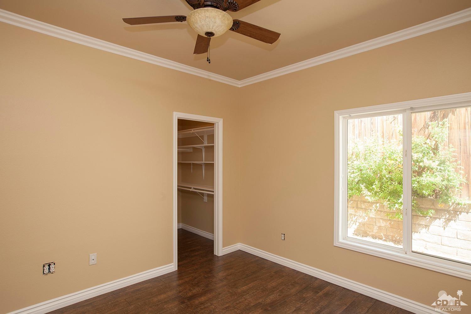 79338 Cool Reflection La Quinta, CA 92253 - Photo 10 of 16 an empty room with a window and ceiling fan