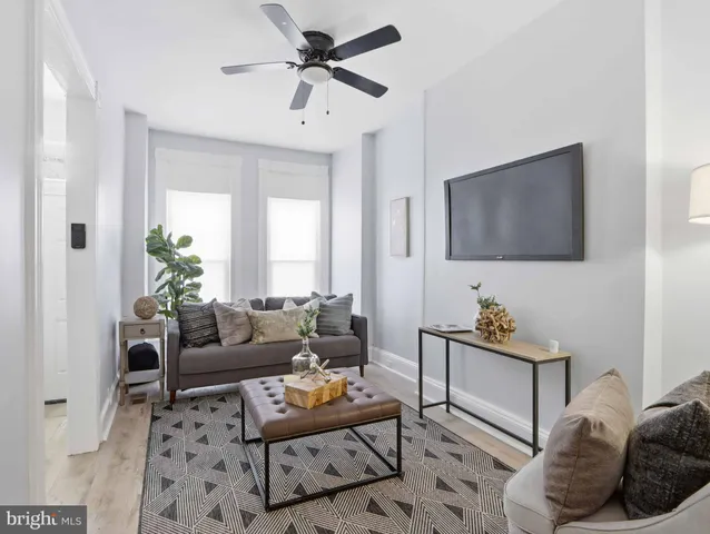 a living room with furniture a window and a flat screen tv