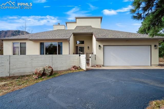 4385 Sandstone Road Monument, CO 80132 - Photo 6 of 50 View of front of house featuring a shingled roof, stucco siding, asphalt driveway, an attached garage, and a chimney