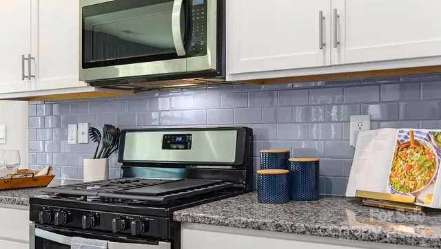 a kitchen with stainless steel appliances granite countertop a stove and a microwave