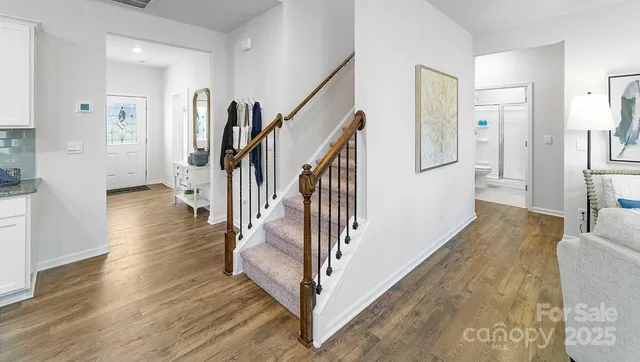 a view of a hallway with wooden floor and staircase