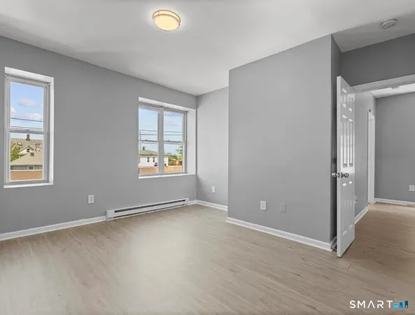 an empty room with windows and closet
