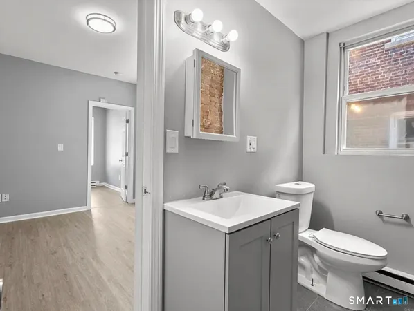 a bathroom with a toilet a sink and mirror