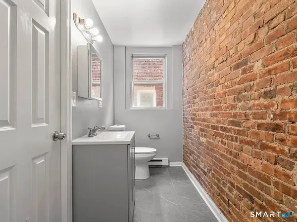 a bathroom with a toilet a sink and mirror