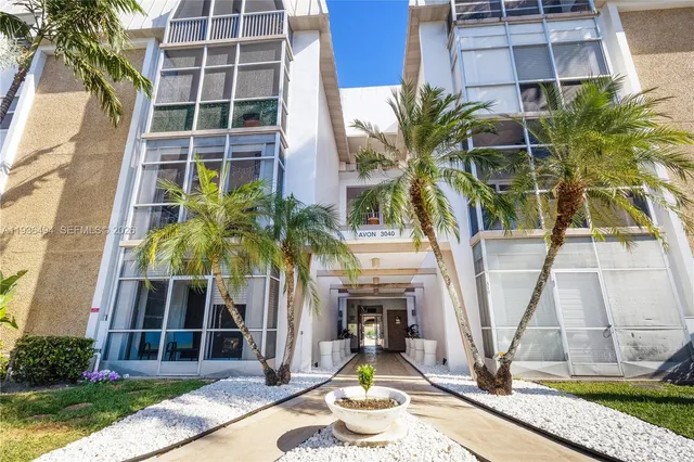 a front view of a multi story residential apartment building with yard