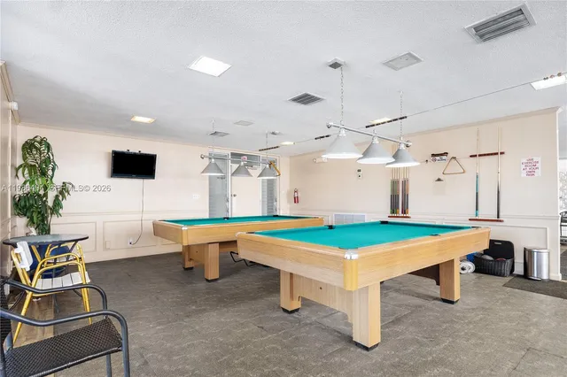 a room with pool table and windows