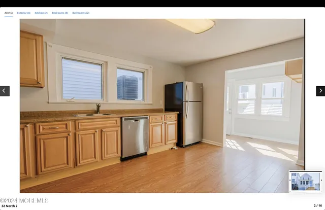 a kitchen with stainless steel appliances granite countertop a refrigerator a sink dishwasher and wooden cabinets with wooden floor