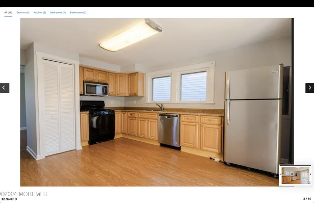 a kitchen with granite countertop a refrigerator stove top oven and sink