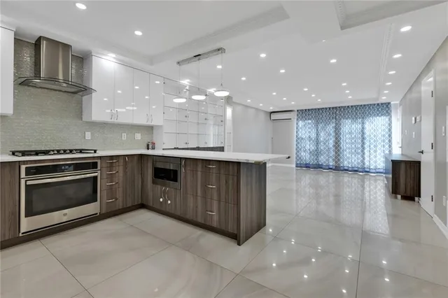 a large kitchen with stainless steel appliances granite countertop a large counter top and a stove top oven