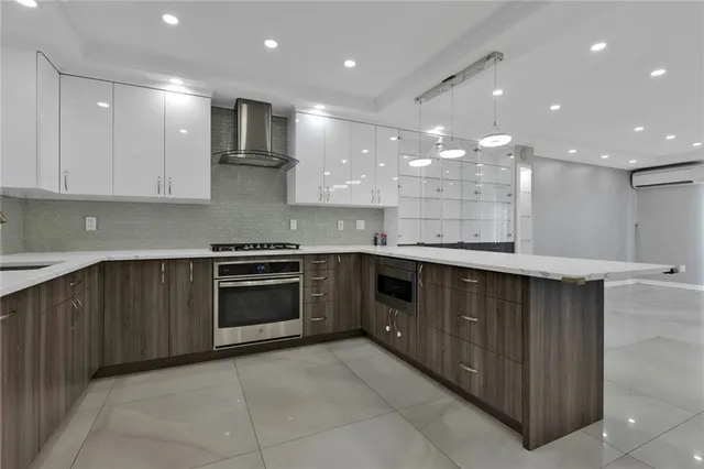 a large kitchen with stainless steel appliances granite countertop a large counter top and a stove top oven