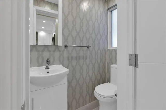 a bathroom with a sink toilet and a mirror