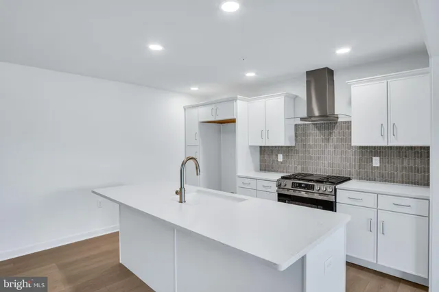 a kitchen with stainless steel appliances a sink dishwasher a stove and white cabinets