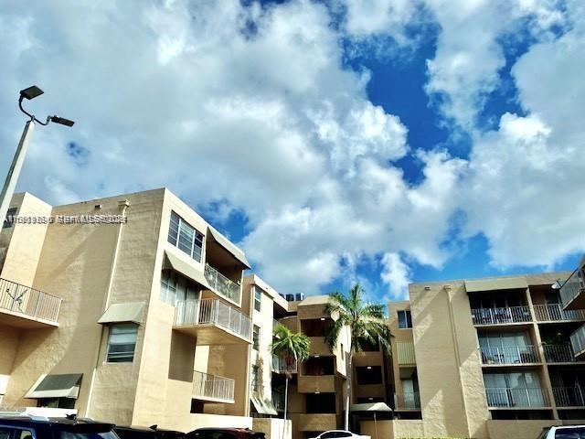 a front view of a multi story residential apartment building with yard