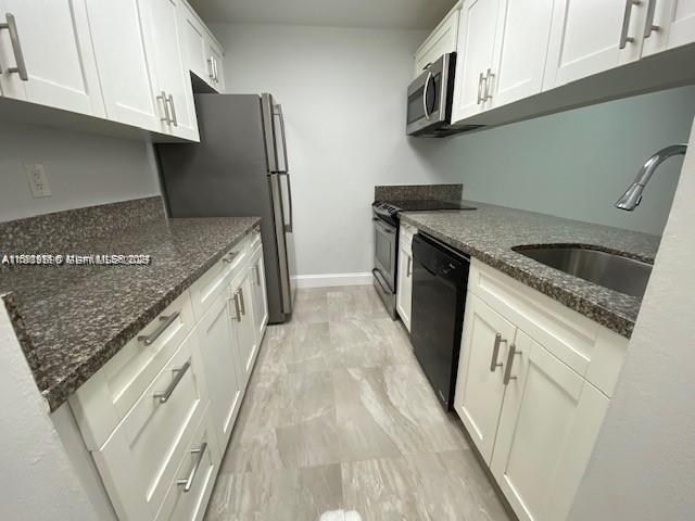 10801 Southwest 109th Court, Unit D103 Miami, FL 33176 - Photo 4 of 12 a kitchen with granite countertop a sink stove and refrigerator