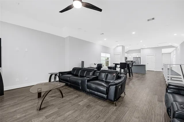 a living room with furniture and a wooden floor