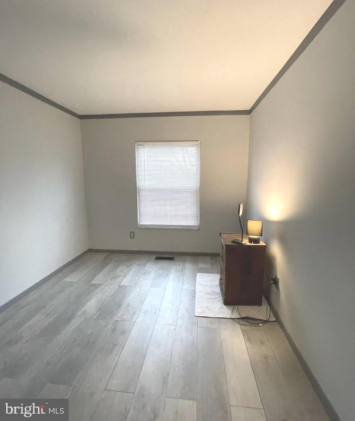 6 Ridgelawn Road, Unit C Reisterstown, MD 21136 - Photo 19 of 28 an empty room with wooden floor and windows