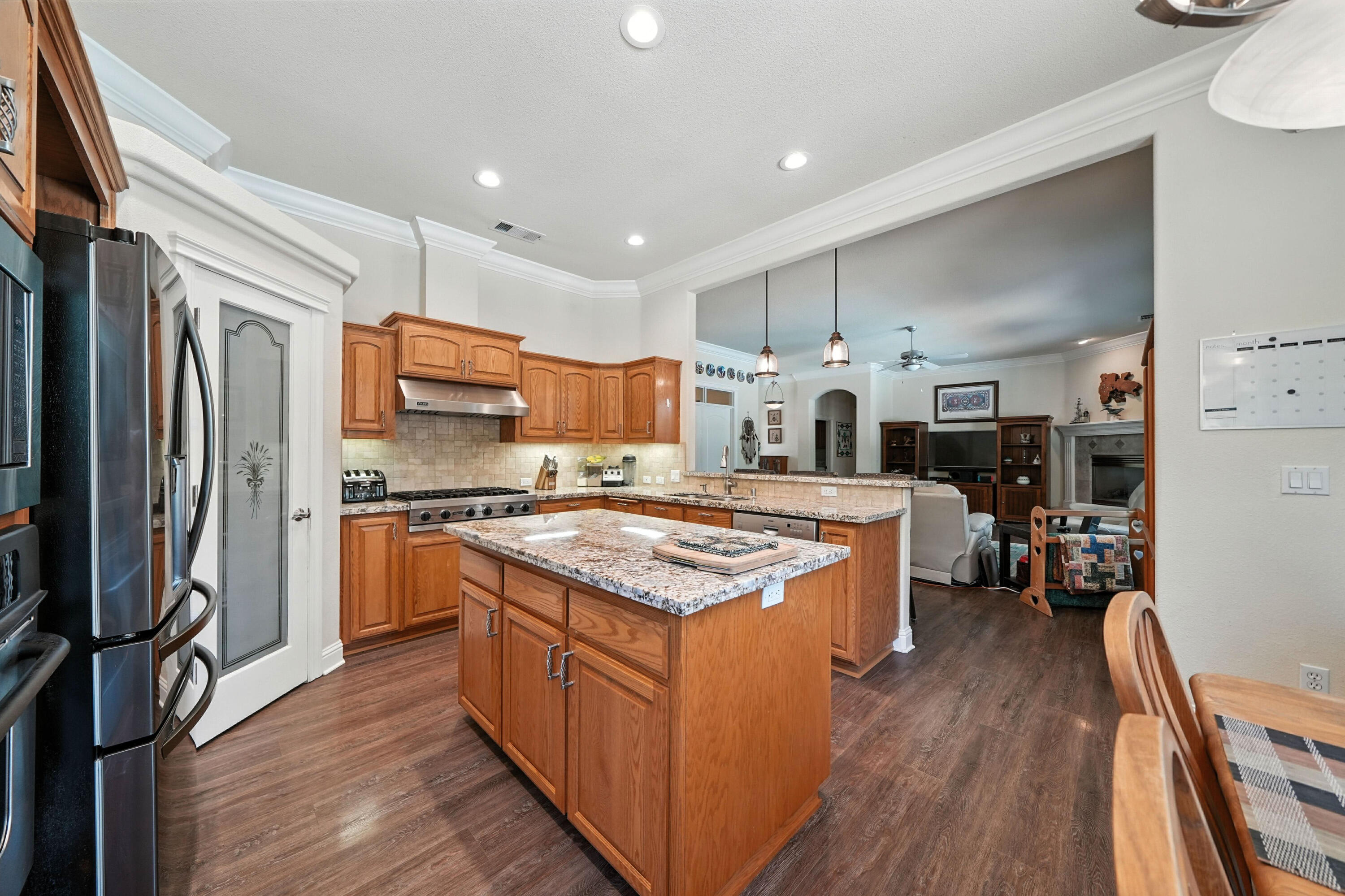 7777 Pit Road Redding, CA 96001 - Photo 8 of 27 a kitchen with stainless steel appliances granite countertop a stove top oven a refrigerator a sink and dishwasher with wooden floor